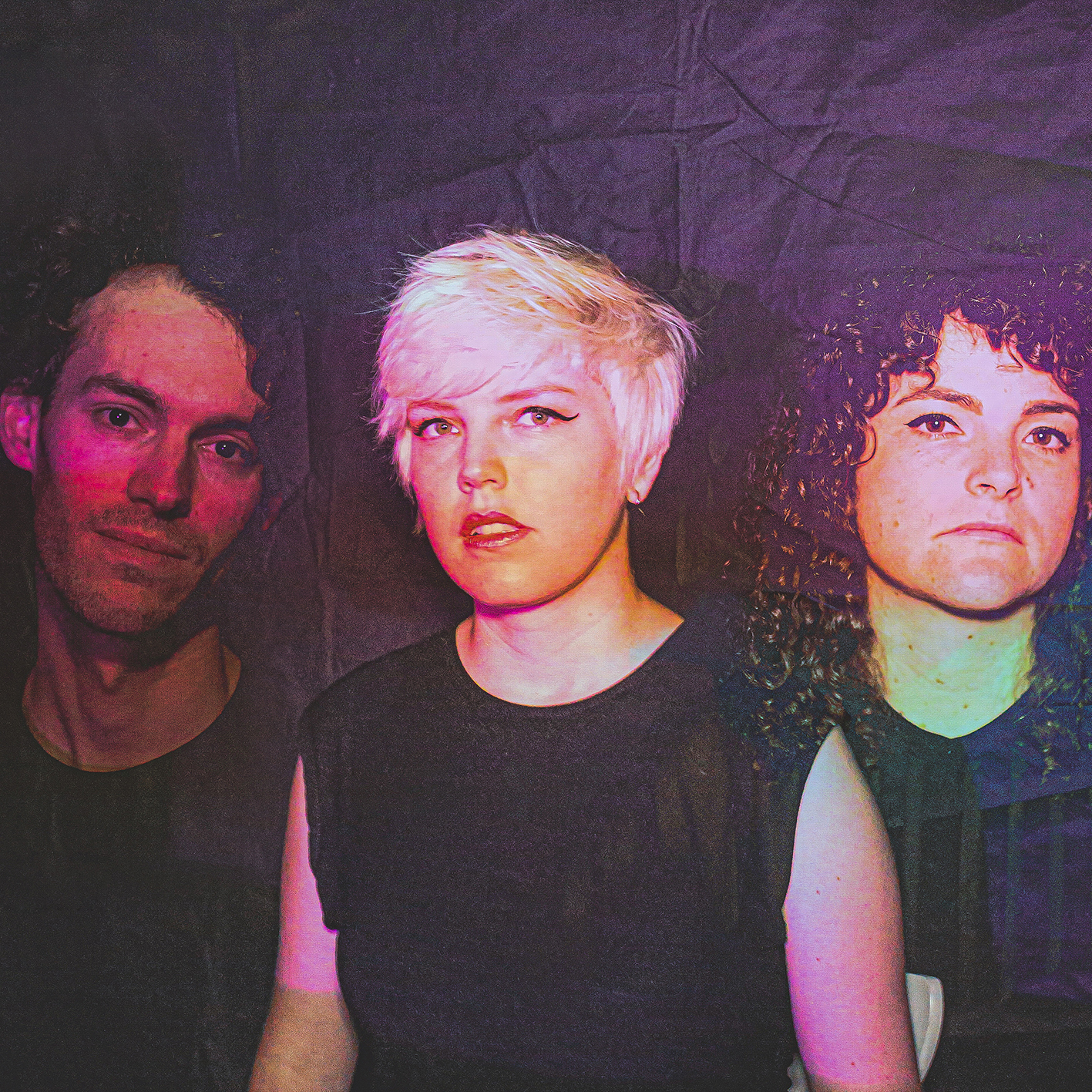 A photo of three musicians with a pink and purple wash over them