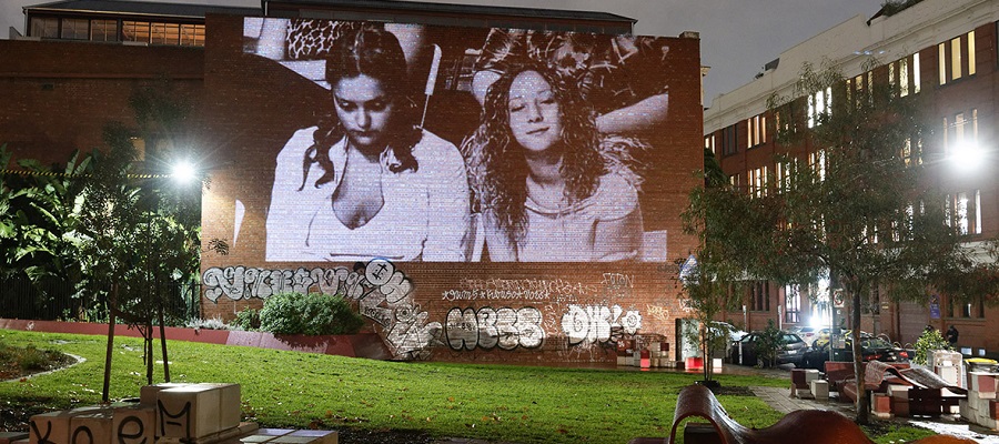 Projection of two women from an audience on a wall at Peel Street Park