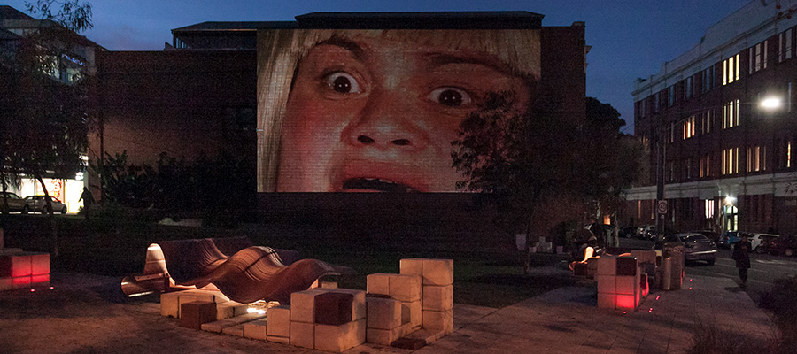 Projections being shown on the side of a building in Peel Street Park