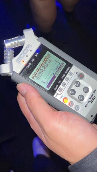 A cropped image of a hand holding a piece of audio recording equipment