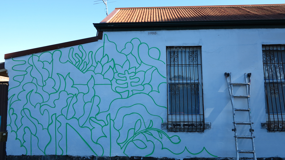 The outline of the mural in green on a white wall.
