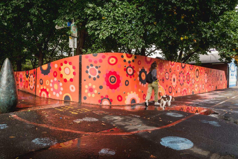 Arkie Bartons mural on Alexandra Parade which features reds oranges and black